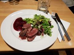Fleisch und Salat angerichtet auf einem Teller im Restaurant